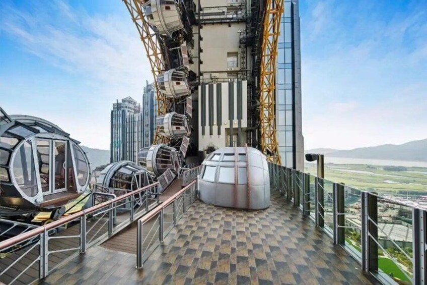 A high-rise building with a glass facade, a helipad, and a view of the surrounding landscape. 3
