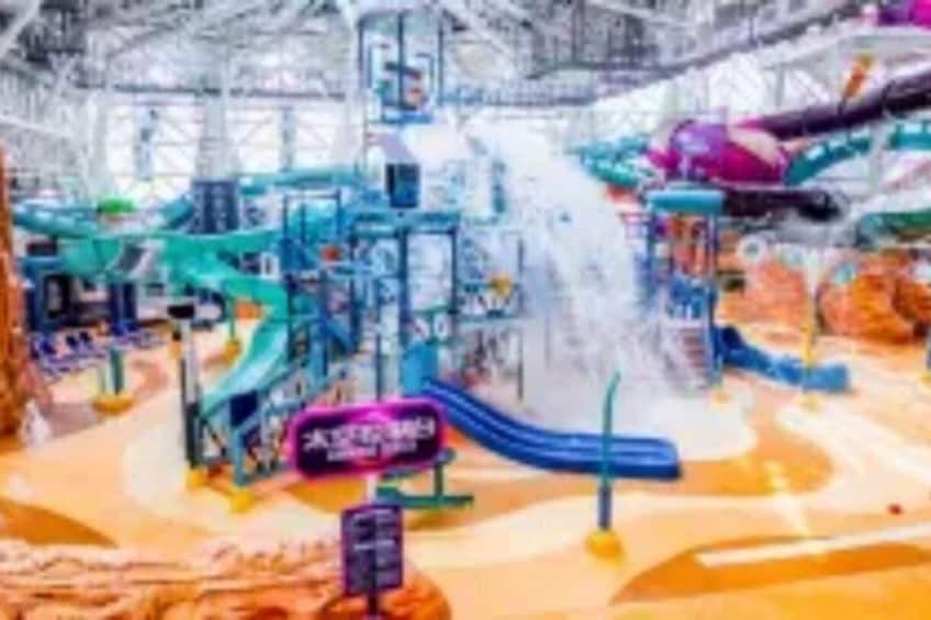 An indoor water park with slides, splash pads, and play structures. 4