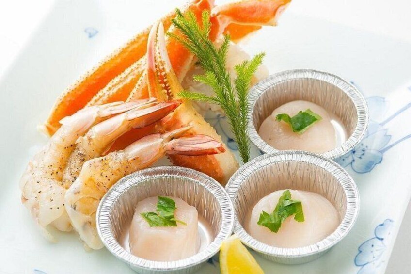 A plate with seafood, including shrimp and crab, and three small cups of a creamy substance, possibly a dip or sauce. 5