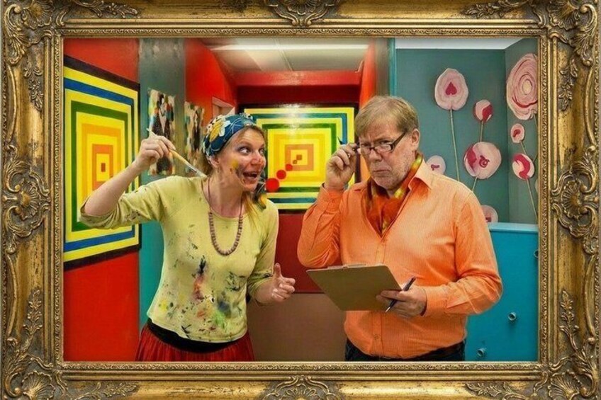 Two people in a colorful room with a painting of concentric squares and a door with circular decorations. 1