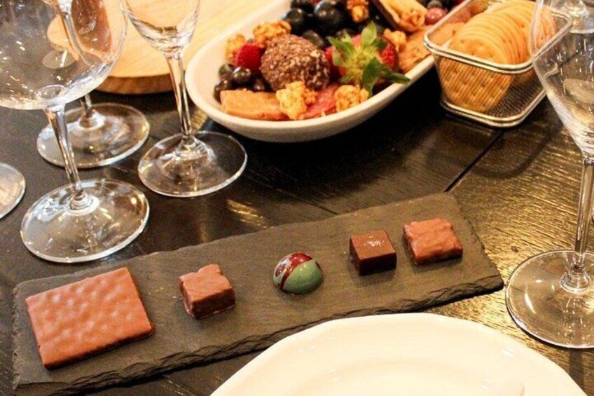 A dessert platter with various sweets and a wine glass. 5