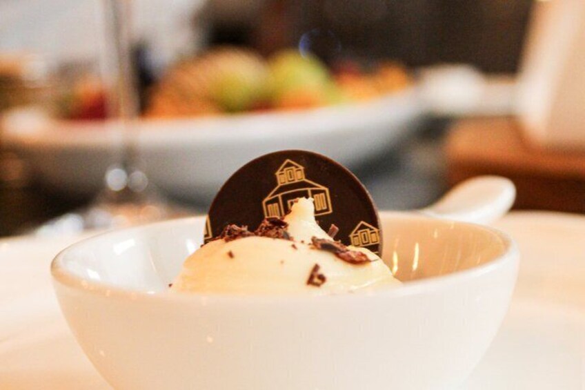 A dessert in a white bowl with a chocolate piece on top. 5
