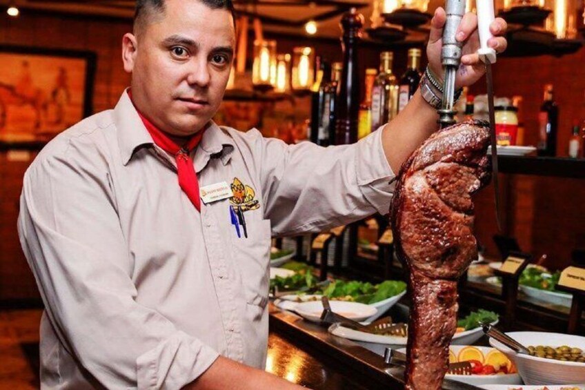A person carving a large piece of meat. 2