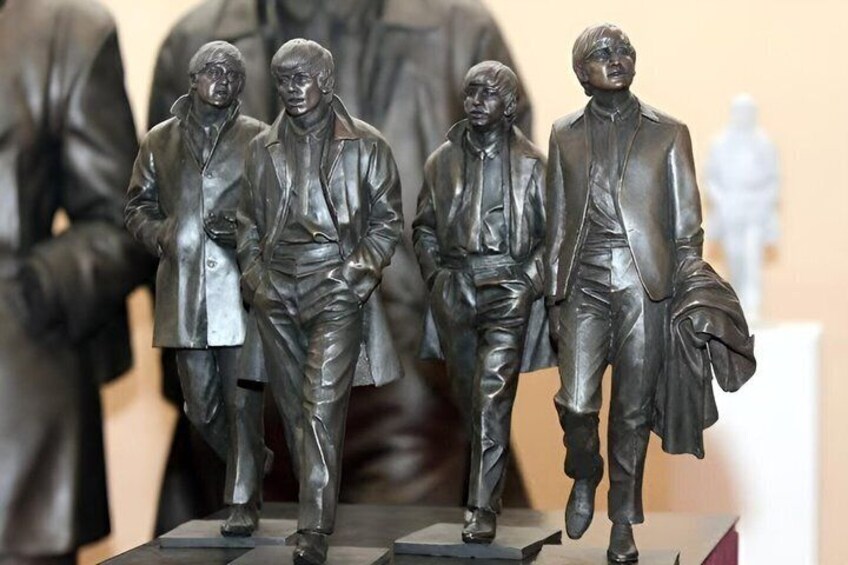 A group of bronze statues of men in suits. 4