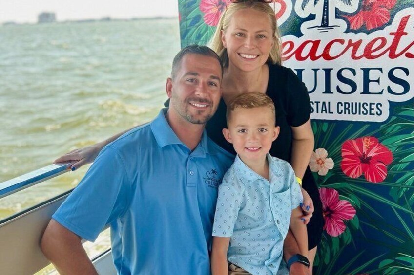 A family on a boat with a backdrop of tropical flowers and the text 'Peacrets Cruises.' 3