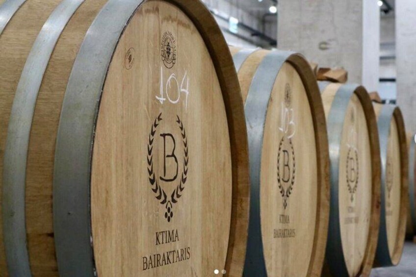 Wooden barrels with metal bands, each marked with a letter and number. 5