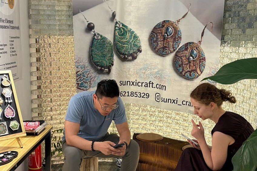 A jewelry display with earrings and a website address. 2
