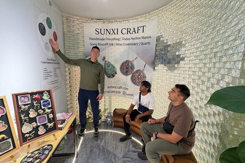 A craft exhibition with handmade items, a banner, and a patterned wall. 4