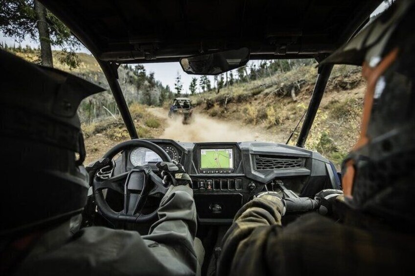 A vehicle's interior with a steering wheel, dashboard, and a person in the driver's seat. 4