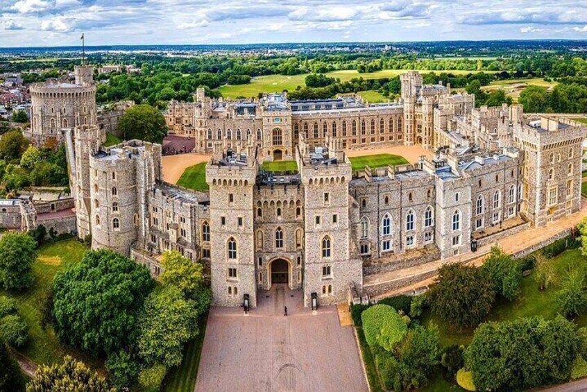 A large, historic stone castle with multiple towers and a central courtyard. 1