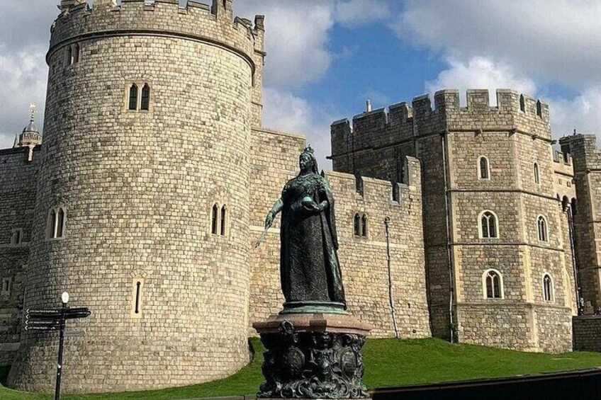 A castle with a round tower and a statue in front. 3