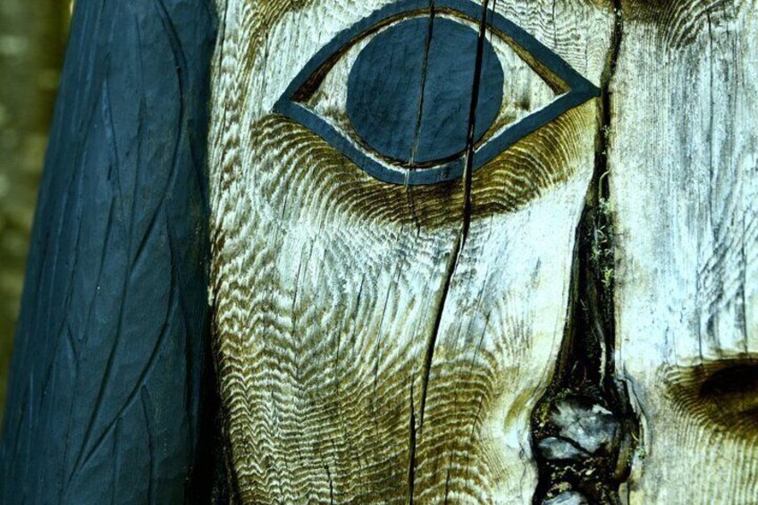 A wooden surface with a carved eye and a geometric pattern. 4
