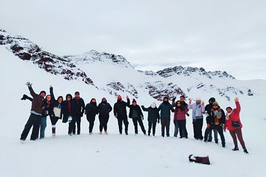 A group of people standing in a snowy mountainous area. 3
