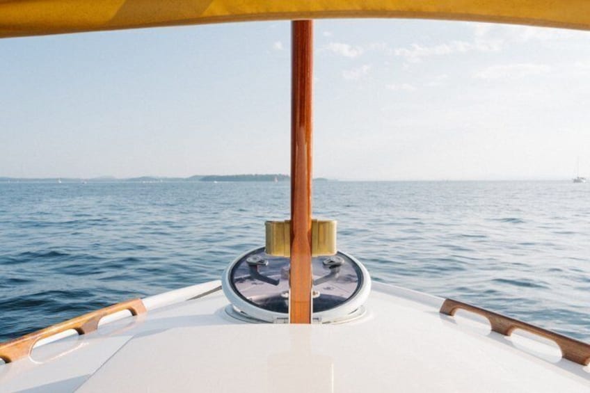 A boat's deck with a wooden pole, a steering wheel, and a circular window. 2
