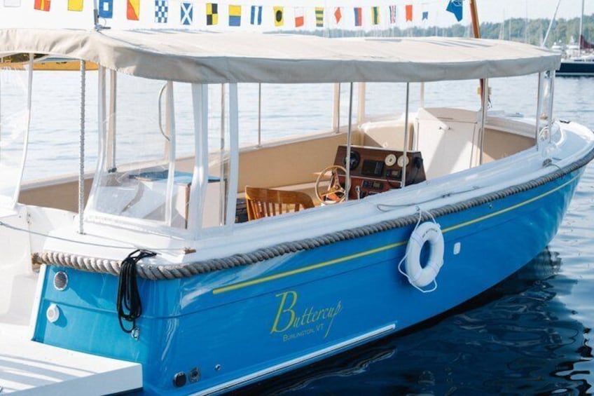 A blue boat named 'Bartonby' docked at a marina with a white canopy and a lifebuoy on the side. 4