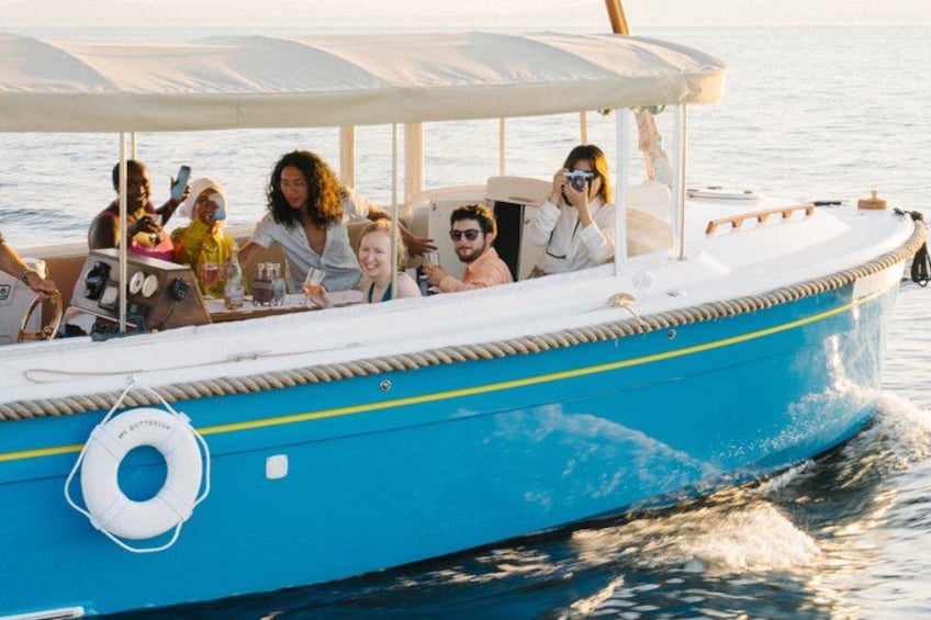 A blue boat with people on board, a lifebuoy, and a wake behind it. 3
