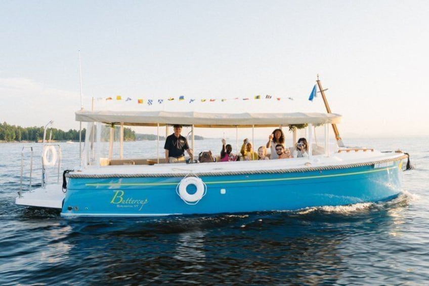 A blue boat with 'Battery's' written on the side, people on board, and a flag at the stern. 1