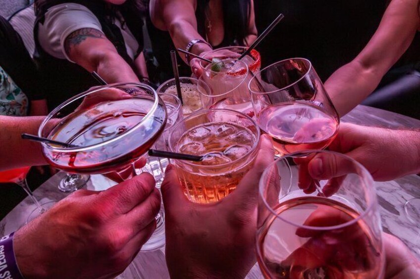 A group of people holding various glasses of beverages, likely at a social gathering. 4