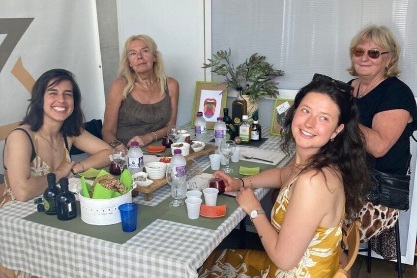 A group of people seated around a table with food, drinks, and a cake. 4