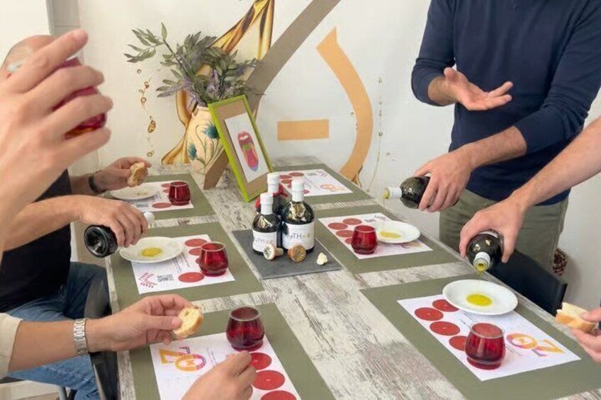 A group of people around a table with food, drinks, and a framed picture. 1