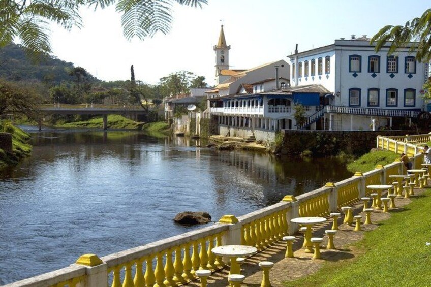A river with a bridge, buildings, and a tower. 2