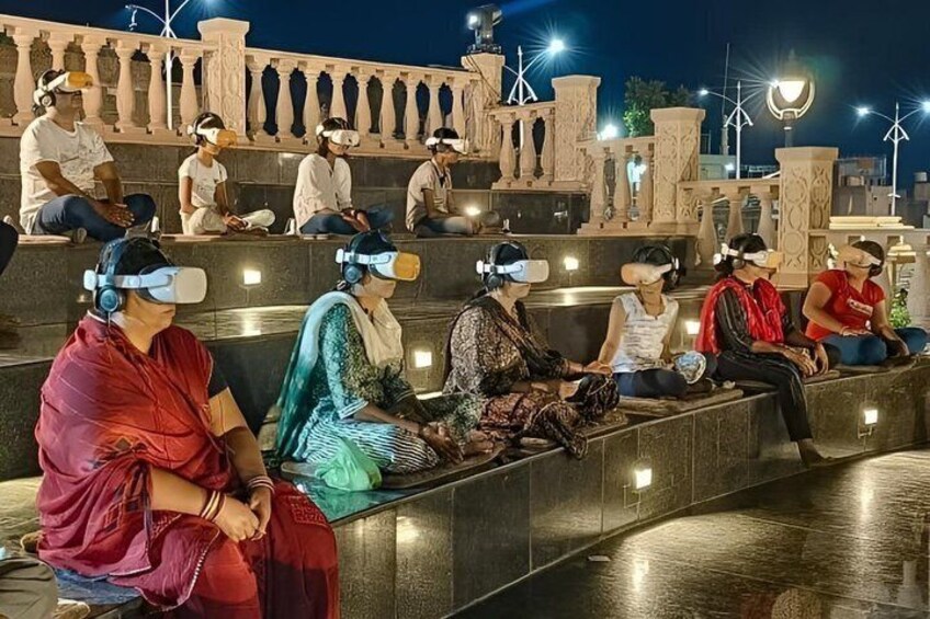 People sitting on steps wearing VR headsets. 4