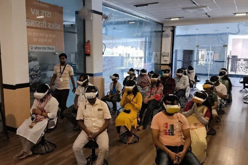 A group of people wearing VR headsets in a room with a poster on the wall. 5