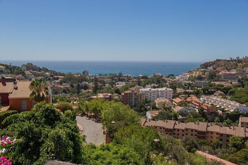 A coastal town with buildings, greenery, and a view of the sea. 3