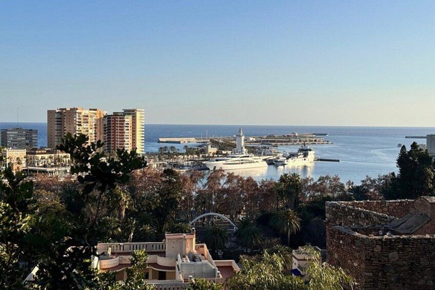 A coastal cityscape with buildings, a lighthouse, and a marina. 2