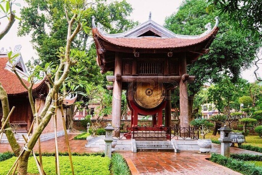 A traditional pavilion with a circular wooden structure, surrounded by a well-maintained garden with stone lanterns and neatly trimmed hedges. 1