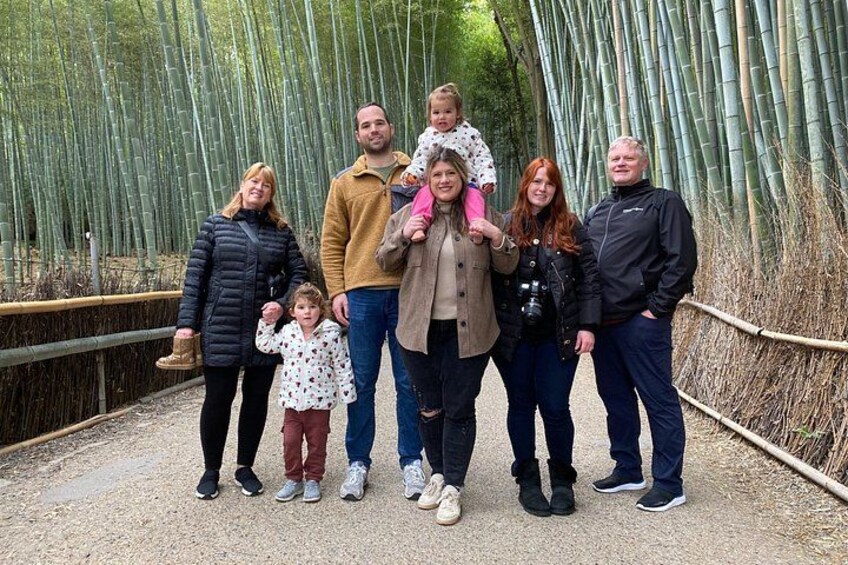 A group of people standing on a path surrounded by bamboo. 5