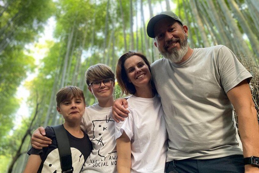 A family of four in a forested area with tall trees. 3