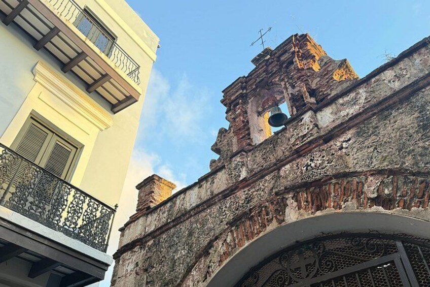 A building with a balcony and a weathered tower. 5