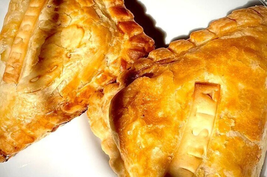 A close-up of a golden-brown pie with a flaky crust, possibly a meat pie. 4