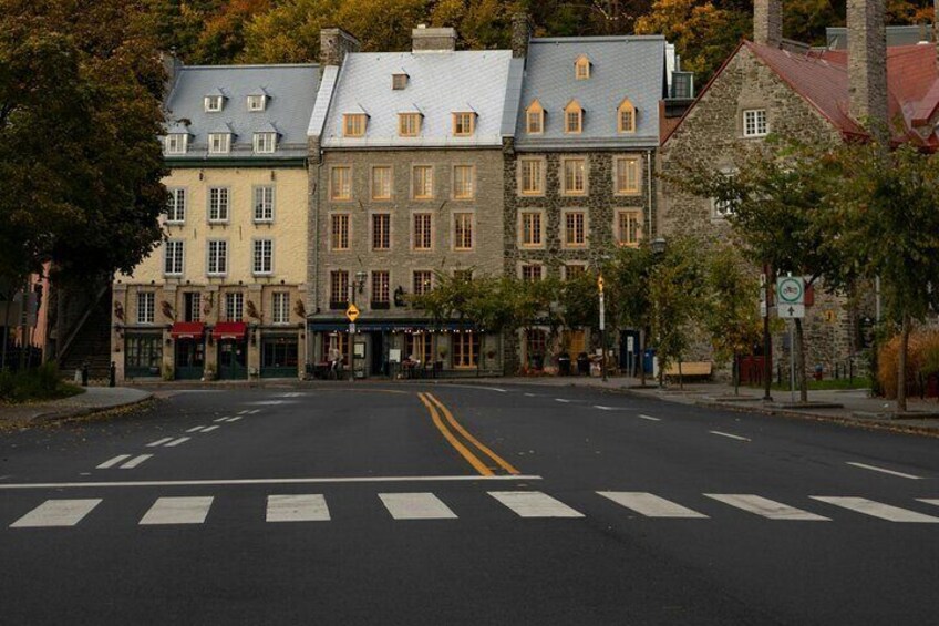 A street with buildings, a pedestrian crossing, and a traffic sign. 5