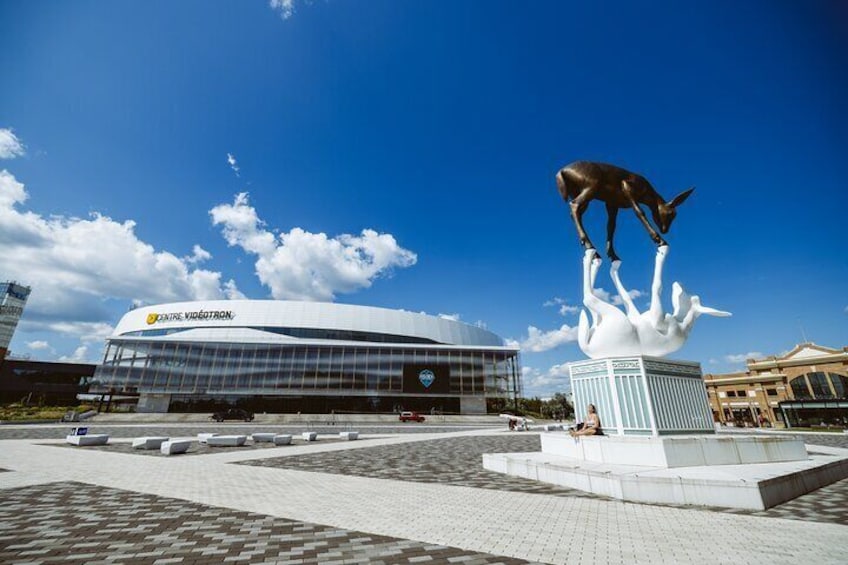 A modern building with a sign reading 'CENTRE VIGORATRON,' a large kangaroo statue, and a clear blue sky. 4