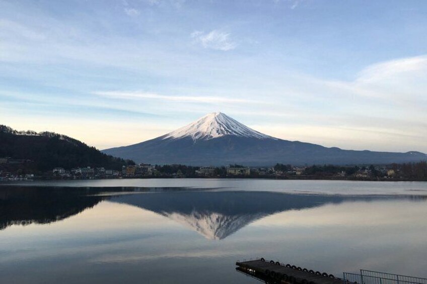 A snow-capped mountain, a calm lake, and a dock. 3