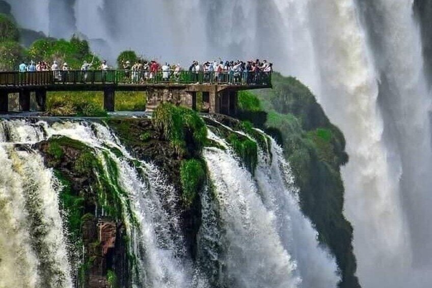 A waterfall with a viewing platform and people observing. 2