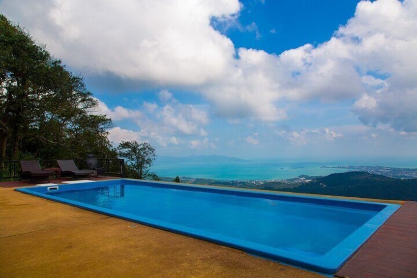 A swimming pool with a view of the ocean and mountains. 4