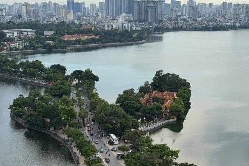 An aerial view of a park with a traditional pagoda, a bridge, and a calm river. 2
