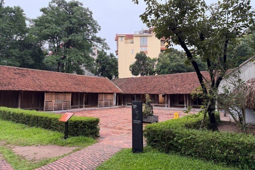 A courtyard with tiled-roof buildings, a paved walkway, and greenery. 4