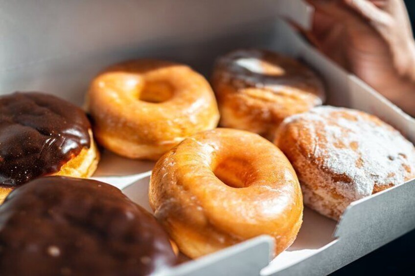 A box of assorted donuts with chocolate and powdered sugar toppings. 1
