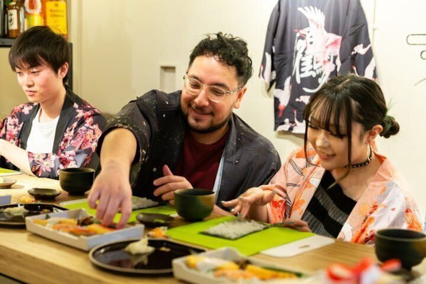 A group of people dining at a table with various dishes and bowls. 1