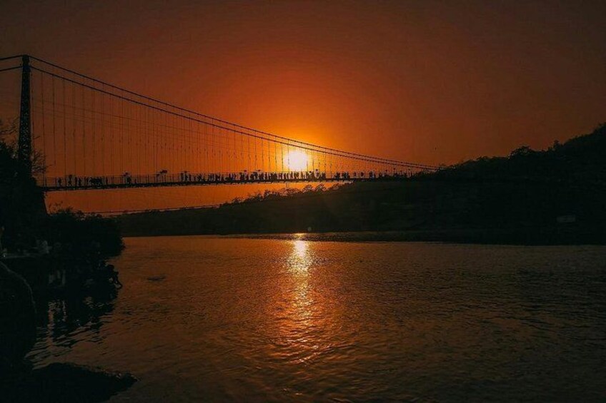 A bridge at sunset with the sun reflecting on the water. 4