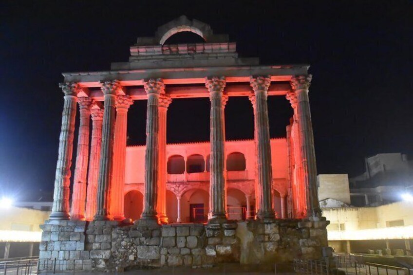 A classical building with columns and arches at night. 4