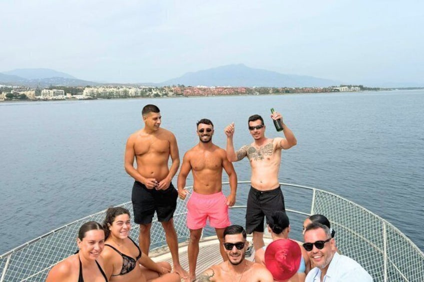 A group of people on a boat with a lake and mountains in the background. 5