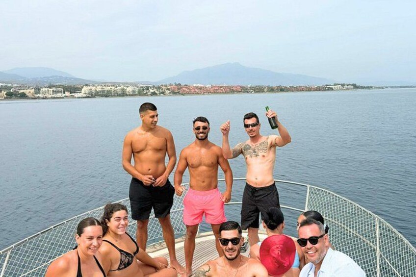 A group of people on a boat with a lake and mountains in the background. 3