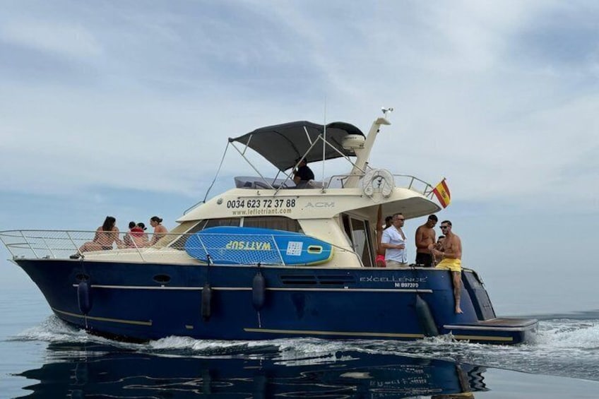A blue boat with people on board, a flag, and a website address. 2