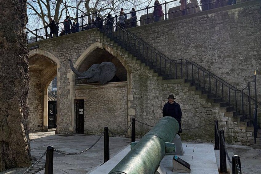 A stone structure with an elephant sculpture, a large cannon, and a staircase. 5