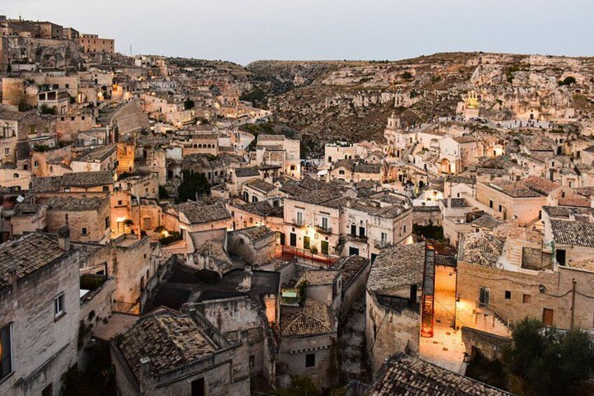A densely packed town with historic buildings, narrow streets, and a hillside backdrop. 5